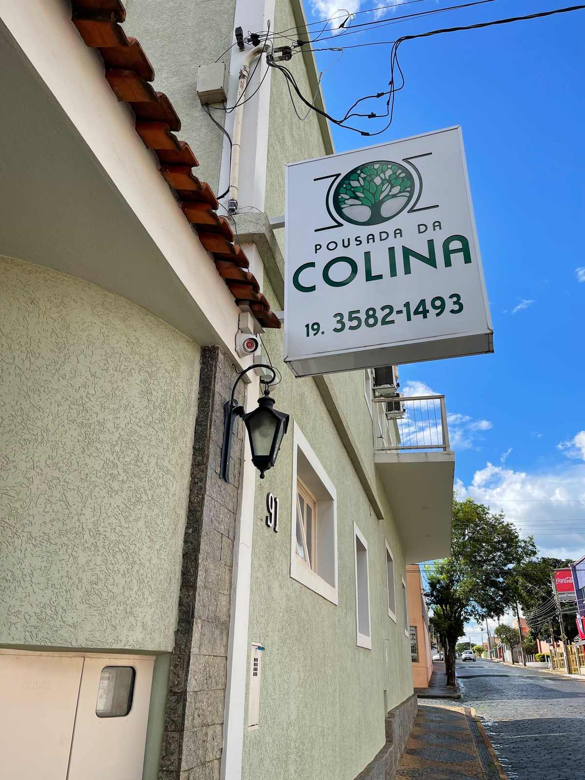 Fachada da pousada com placa Pousada da Colina